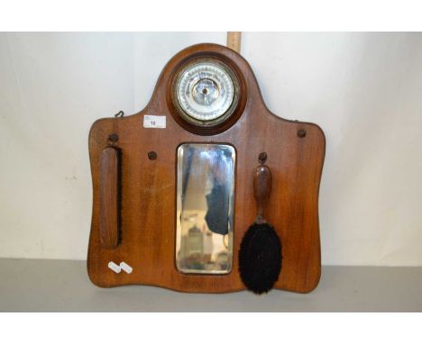 A hall mirror in wooden frame complete with two brushes and barometer at the top