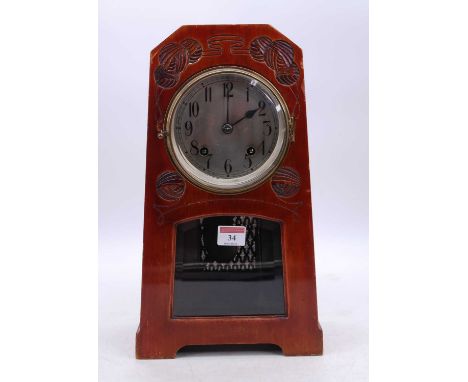 An Arts &amp; Crafts walnut mantel clock, the silvered dial showing Arabic numerals, the eight day movement striking on a gon