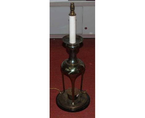 A large 20th century brass table lamp, standing upon a tripod base and ebonised plinth, h.84cm