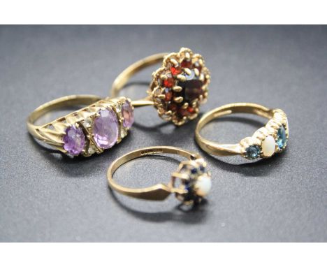 A modern 9ct gold garnet set flower head cluster ring; together with an amethyst three stone ring; a sapphire and opal small 