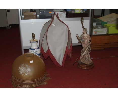 A vintage figural resin table lamp; together with a porcelain example; two amber glass shades; and a further shade 