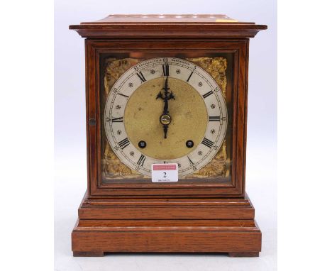An early 20th century oak cased bracket clock, the silvered chapter ring showing Roman numerals and surrounded by pierced mas