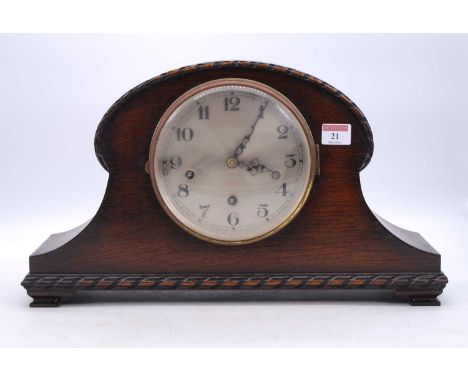 An early 20th century oak cased mantel clock, the silvered dial showing Arabic numerals, the eight-day movement with chimes, 