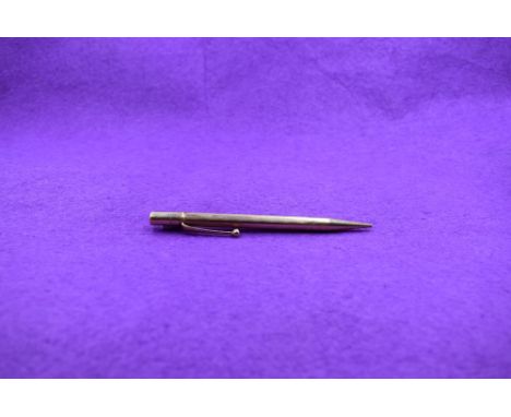 A Propelling pencil in 9ct gold with engine turned decoration, stamped 9 .375 to tip, barrel and clip.