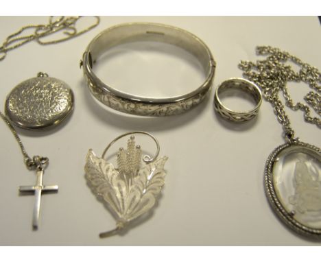 A silver hinged bangle;  a silver locket;  a silver leaf brooch;  a pendant, 