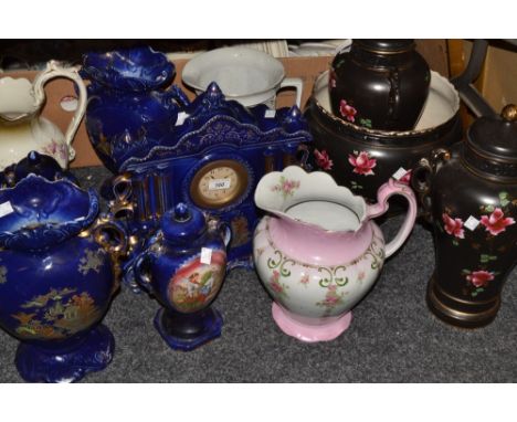 A large blue ceramic garniture comprising mantel clock, a pair of two-handled urns and another pair, smaller;  a large black 