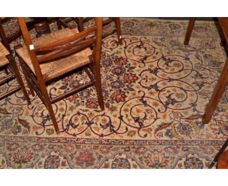 A Persian Isfahan woollen rug, with central floral roundel amongst foliage scrolls, meandering border, on a cream ground,  24