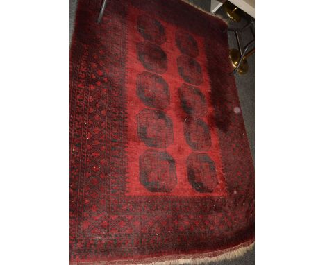 An Afghan woollen carpet,  with ten reserves on a red ground,. geometrical border, 242cm x 171cm