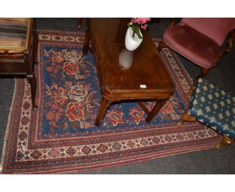 A Persian Afshar woollen rug, with five floral clusters in tones of red and white on a blue ground, geometrical border, 185cm