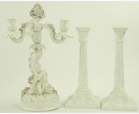 An ornate German white glazed porcelain 3 branch candelabrum, surmounted by a classical cherub, height 34 cm, blue under glaz