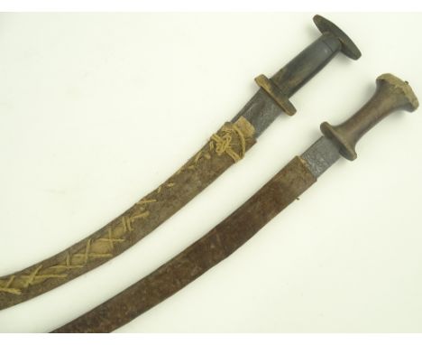 2 Ethopian curved swords, 18th/ 19th century, embossed blades with carved rhino horn handles, blade length 83 cm & 69 cm, lea