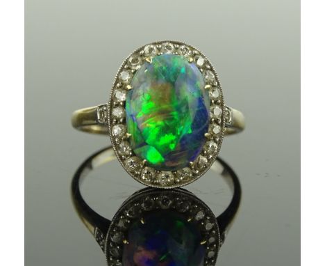 A black opal & diamond cluster ring, c 1920s, opal 12mm x 8 mm, unmarked gold settings, setting height 16 mm, size O