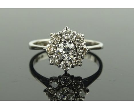 An 18 ct white gold diamond cluster ring, total diamond content approx 0.7 carats, setting height 10 mm, size M