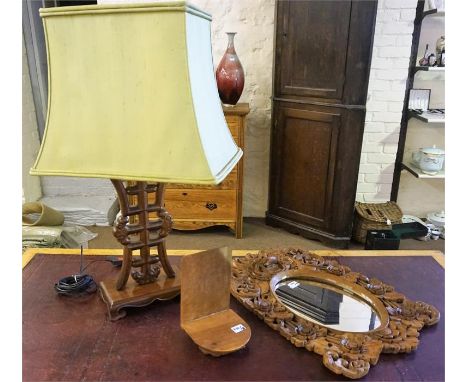 A Chinese Hardwood Table Lamp, with shade, overall 76cm high, also with a carved hardwood stand and a carved wall mirror, (3)