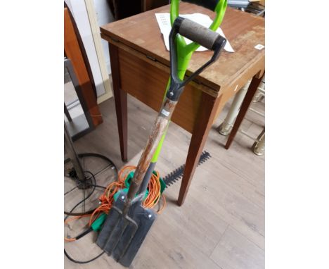 A GARDEN FORK AND SPADE AND ELECTRIC HEDGE TRIMMER