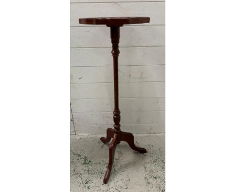 A mahogany plant stand on turned central column and splayed tripod feet 