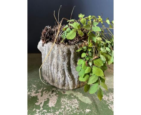 A concrete garden planter in the form of a tree trunk 