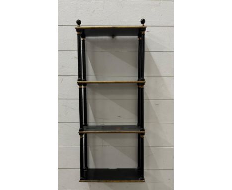 A three shelf black and gold wall hanging unit 