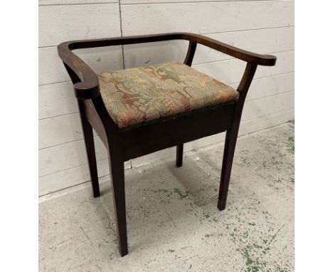 A vintage mahogany piano stool with arms and hinged seat 