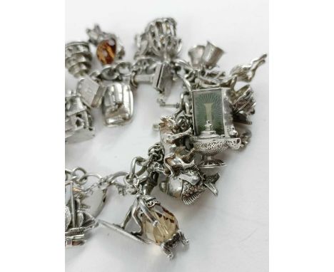 A silver charm bracelet with various charms attached, to include a light house, ships, animals and others, many that open, 11