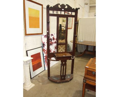 An Edwardian stained mahogany hall stand, the central rectangular mirror plate and single tile above a glove box, flanked by 