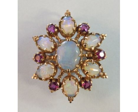 An opal and ruby brooch/pendant claw-set a cluster of seven oval water opals and six round-cut rubies, set in unmarked yellow