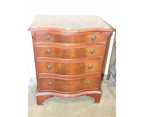 A reproduction mahogany finish low chest, the serpentine top above four graduated drawers, on bracket feet, 59cm wide, 73cm h