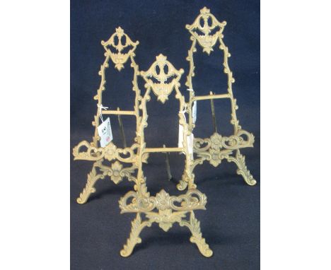 Set of three brass foliate design easel shaped photograph stands. (3)(B.P. 24% incl. VAT) 