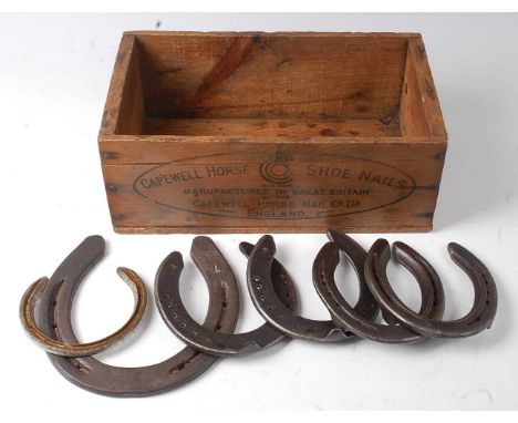 * A stained pine box stamped Capewell Horse Shoe Nails, containing various horse shoes.Condition report: From ‘A Broad Collec