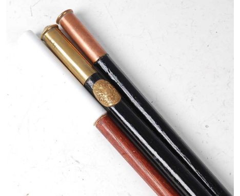 A military swagger stick, having an ebonised shaft and brass tip with Royal Coat of Arms badge, 86cm, together with two other