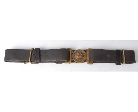 A British Army black leather belt, the brass buckle with a lion above a crown within legend Dieu Et Mon Droit.