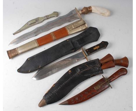 An Indian Kukri having a typical curved blade in a leather sheath with karda and chakmak, together with an Indonesian kris, a