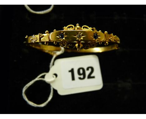 Late 19thC Yellow metal Bangle with inset Diamond flanked by Star set sapphires, 6.7g total weight 