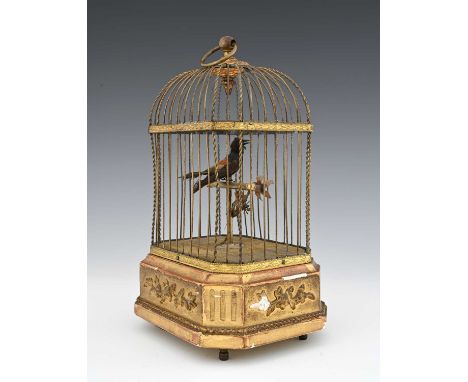 A clockwork automaton singing bird, late 19th or early 20th Century, mounted on a perch with a flower in a gilt wirework cage