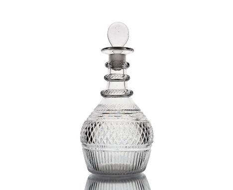 An Anglo Irish glass decanter, circa 1810, Prussian form with three mitre notched ring neck, the body with bands of hobnails,