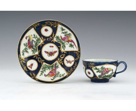 A Worcester powder blue and polychrome tea cup and saucer, circa 1770, painted with Fancy Birds and insects within gilt carto