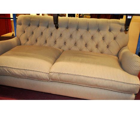 A contemporary buttoned upholstered three-seater sofa, raised on turned beech squat forelegs, width 190cm