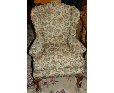 A good pair of early 20th century walnut framed and floral needlework tapestry upholstered wingback scroll arm chairs, each r