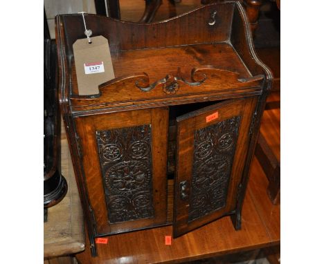 An early 20th century floral relief carved oak double door wall-mounted tobacco cabinet, w.32.5cm 