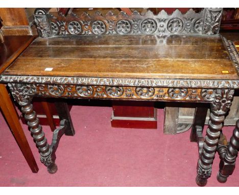 A circa 1900 floral relief carved oak ledge back hall table, raised on bobbin turned supports, width 106cm