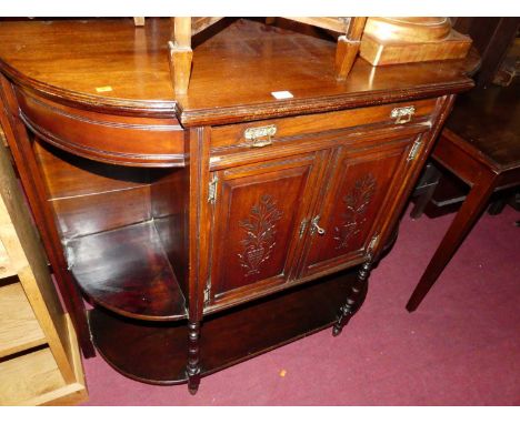 An Edwardian walnut breakfront low side cabinet, having twin cupboard doors, single upper drawer and open shelved compartment