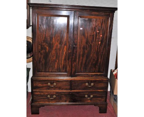 An early 19th century mahogany linen cabinet, the twin recessed panelled upper doors enclosing open interior with hanging rai