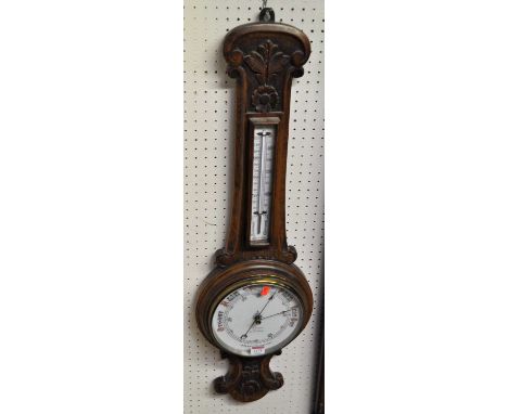 An early 20th century floral relief carved oak aneroid two-dial wheel barometer, height 91cm