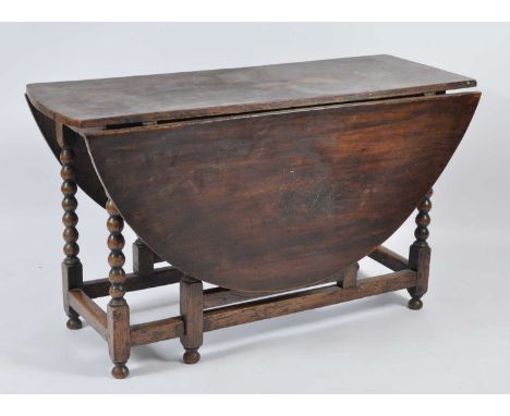 An early 18th century and later joined oak gateleg table, having fall leaves on bobbin turned gatelegs united by low stretche