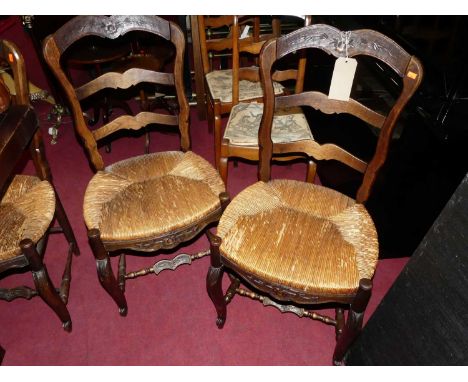 A set of six early 20th century provincial French oak and rush seat ladder back breakfast chairs