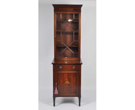 A Sheraton Revival mahogany and inlaid cabinet, of narrow proportions, the upper section with astragal glazed door, the base 