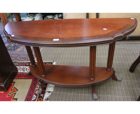 A modern hardwood console table on four column uprights and paw feet