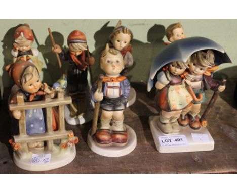 Seven Goebel Hummel ceramic figures, includes two children sheltering beneath an umbrella (7)