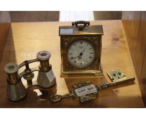 A pair of brass and mother-of-pearl Opera glasses, a "Swiza 8" alarm clock and a cast brass decorative key (3)