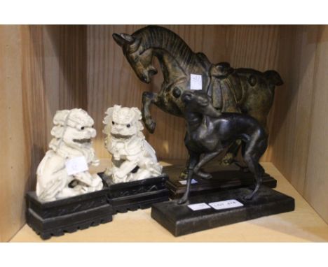 A shelf containing a pair of Dogs of Fo, a tang horse and a metal figure of a greyhound